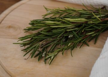Sprigs of rosemary on a wooden board for cutting. Rustic style. Spice